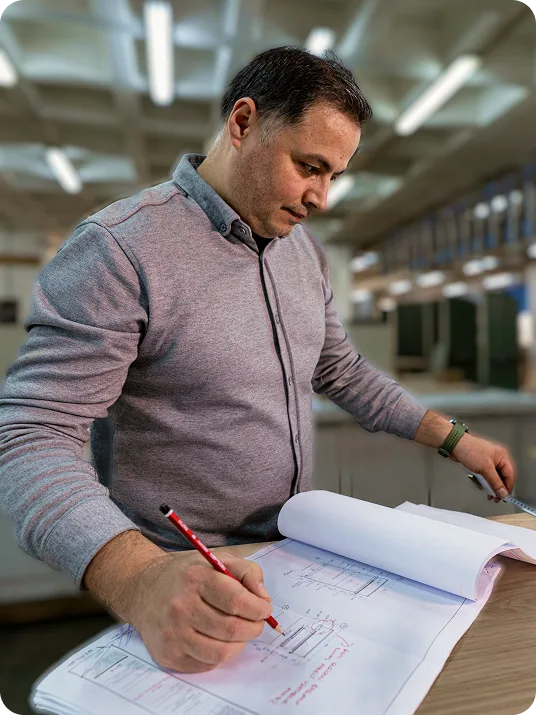 A production specialist checking technical drawings